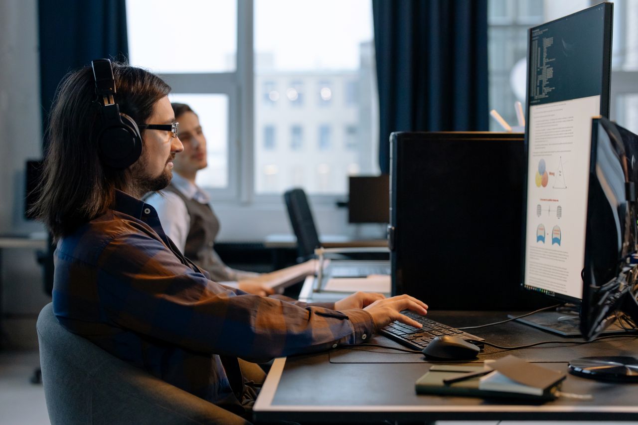 Features Two programmers working together with focus on coding in a modern, tech-savvy office environment.