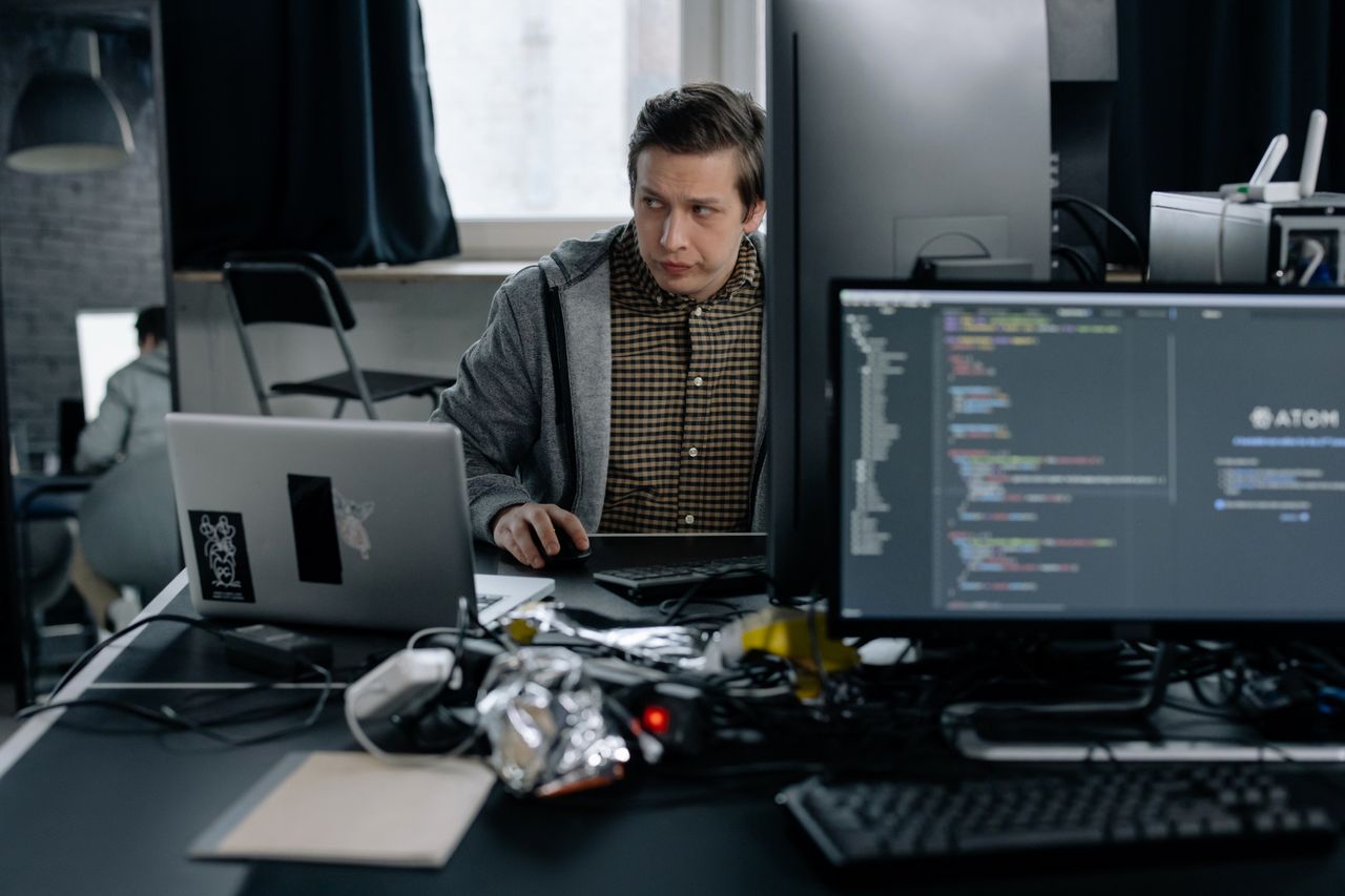 The Art of Drawing Readers In: Your attractive post title goes here A programmer in a modern office working on computer code, showcasing a focused work environment.